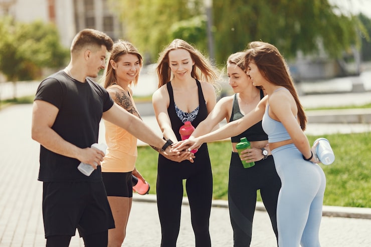 People celebrating healthy lifestyle goals after an outdoor fitness session as part of a wellness program