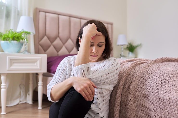 Woman resting on a sofa representing hormonal balance and personalized wellness care.