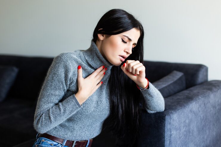 Woman experiencing chest discomfort representing autoimmune health concerns and personalized care.